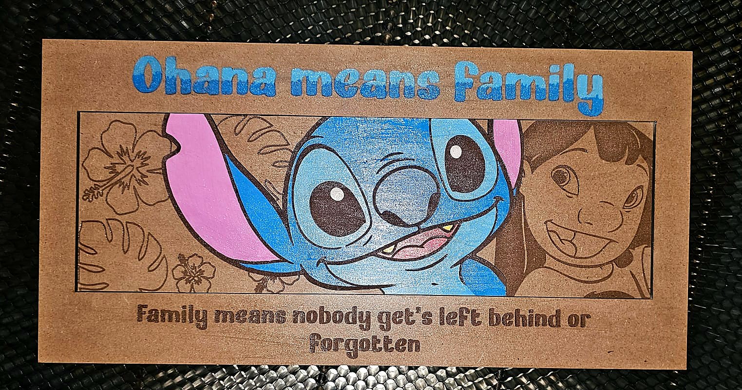 Colour-filled Stitch family plaque engraved on timber