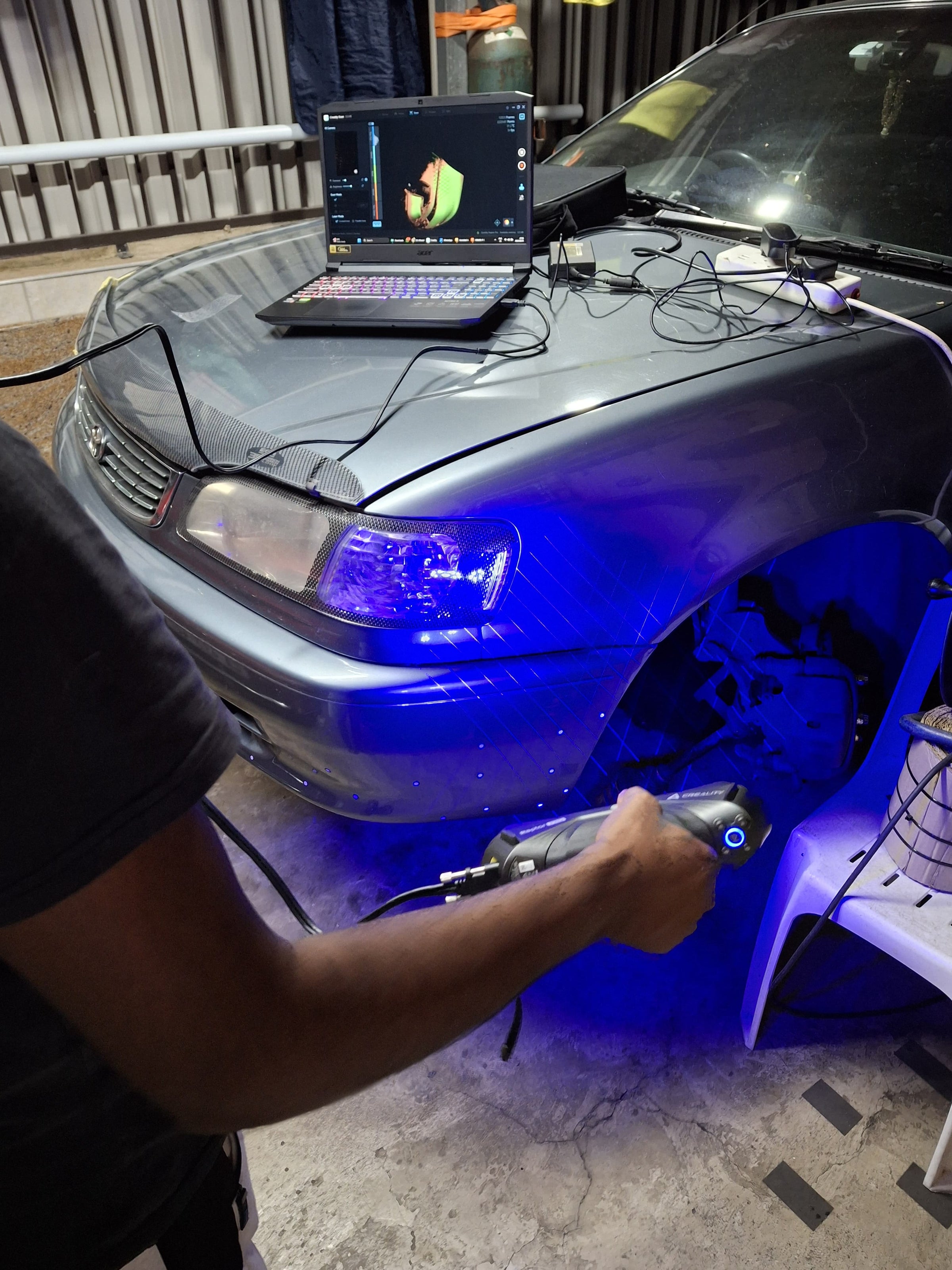 Create It 3D technician scanning a Toyota Corolla with a handheld 3D scanner in South Africa